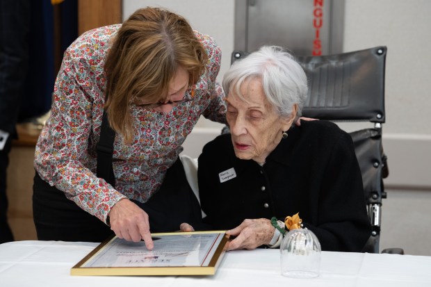 Victoria Semproni, left, looks over a New York senate proclamation with her mother, Marie Semproni, during a birthday celebration for people 100 years old and older at the New Jewish Home in Harlem on Tuesday, Sept. 30, 2025, in Manhattan, New York. (Barry Williams/ New York Daily News)